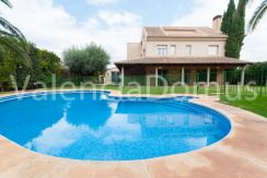 Piscina salada vallada y olivo al fondo
